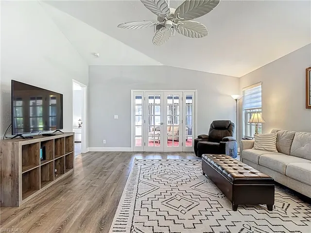 Living room featuring french doors, vaulted ceiling, light wood-style flooring, and ceiling fan