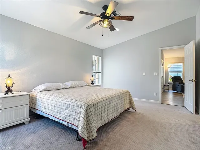 Bedroom with carpet floors, lofted ceiling, ceiling fan, and multiple windows
