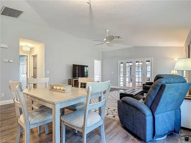Dining area featuring wood finished floors, a ceiling fan, and french doors