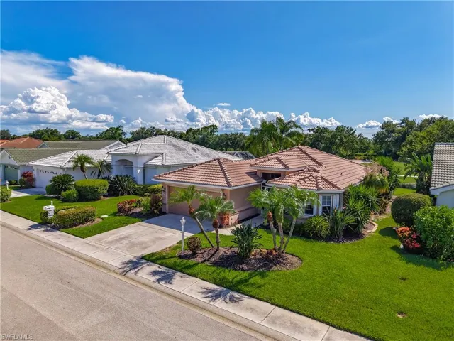 Mediterranean / spanish-style home with driveway, a front yard, a garage, a tile roof, and stucco siding