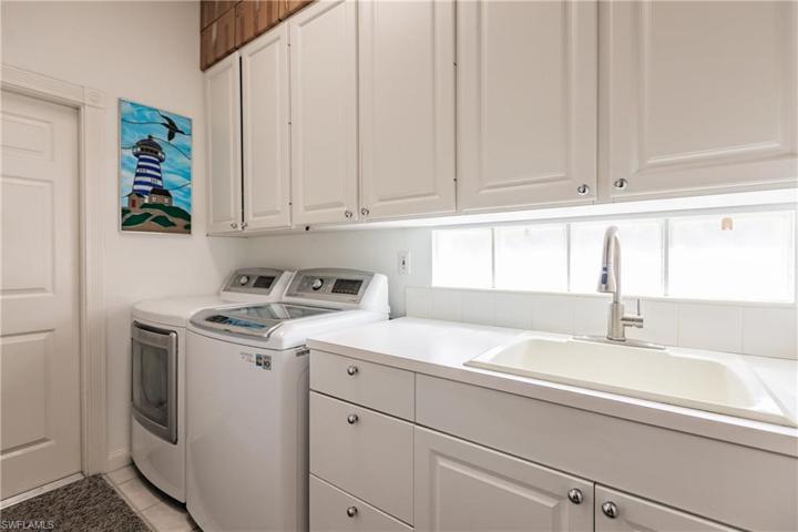 Laundry room has tons of storage and a laundry sink too.