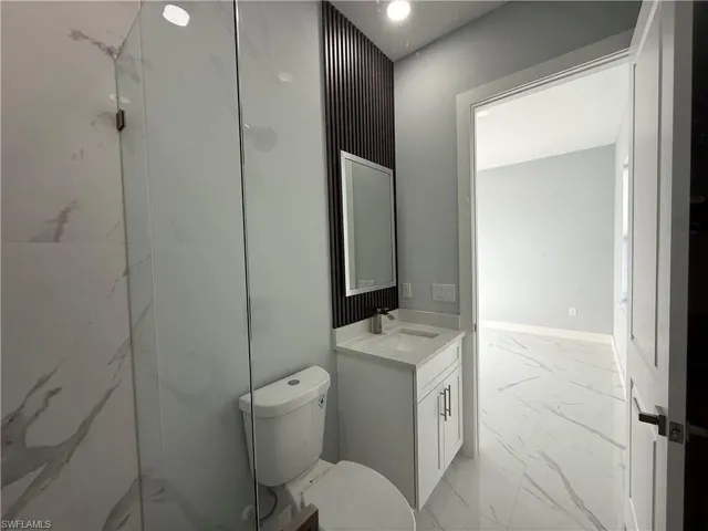 Full bath featuring light marble finish floors and vanity
