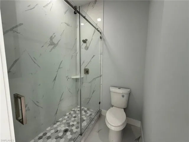 Bathroom with a marble finish shower and marble look tiles