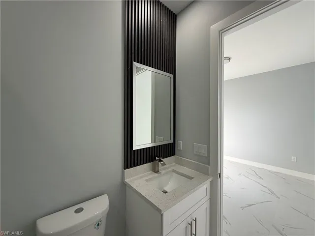 Bathroom featuring vanity and light marble finish floors