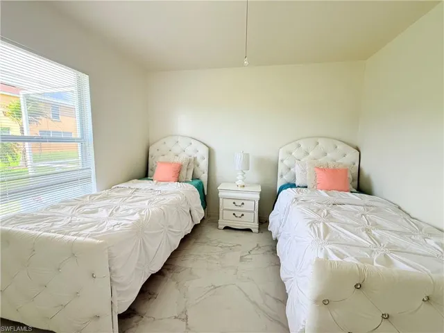 View of swimming pool featuring a patio, a sunroom, a pool with connected hot tub, and glass enclosure