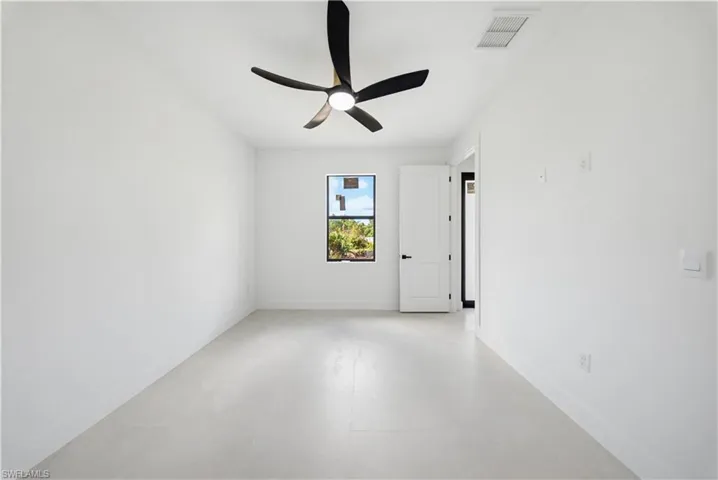 Spare room featuring a ceiling fan and baseboards