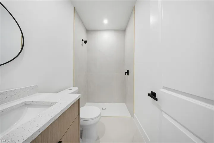 Full bathroom with a shower stall, vanity, light tile patterned flooring, and recessed lighting