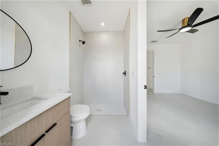 Full bathroom with vanity, ceiling fan, a stall shower, and recessed lighting