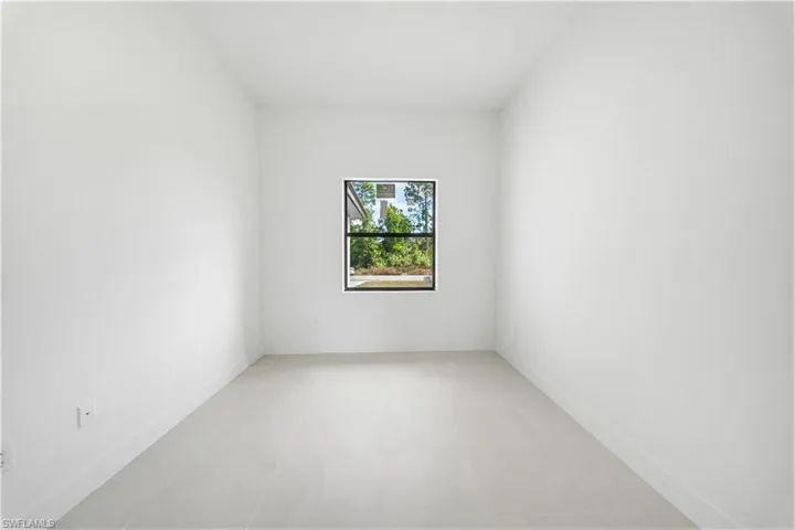 Empty room featuring baseboards and light tile patterned floors