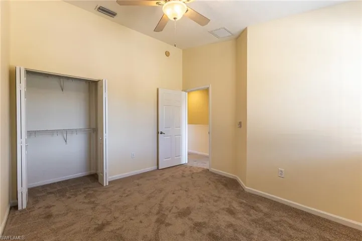 Unfurnished bedroom with carpet, a ceiling fan, and a closet