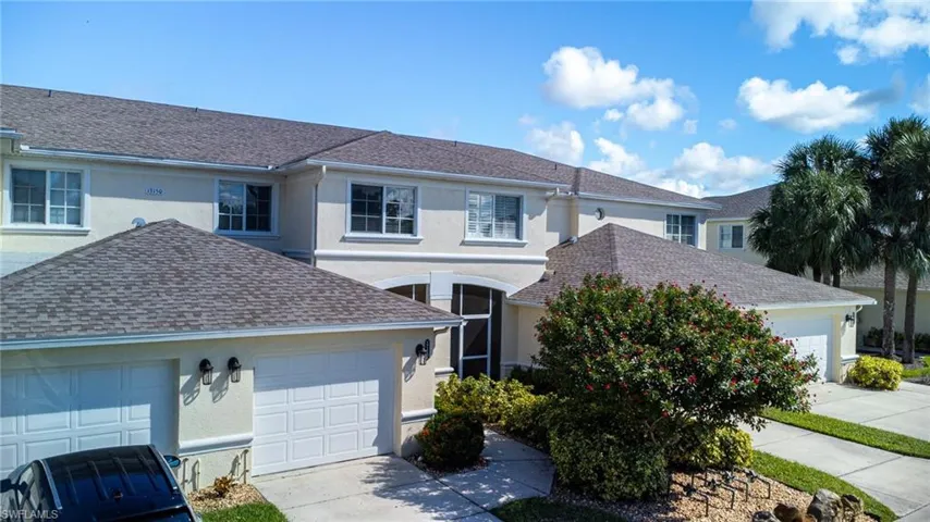 Traditional-style house with stucco siding, a garage, a shingled roof, and concrete driveway