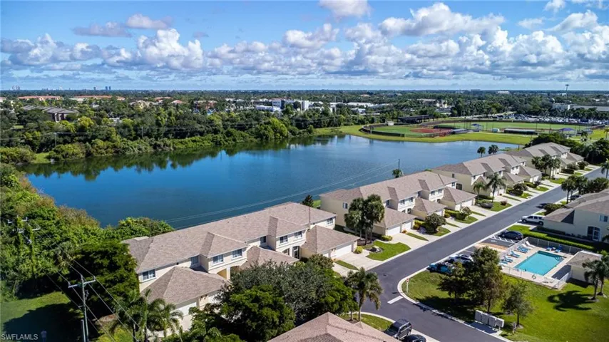 Aerial view of residential area with a large body of water and a tree filled landscape