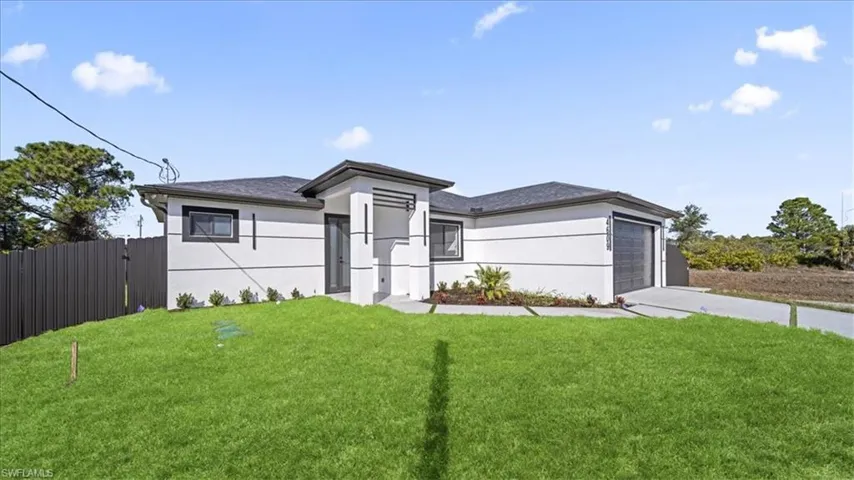 Prairie-style house featuring stucco siding, driveway, an attached garage, and a gate