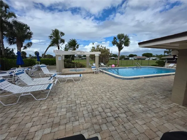Community pool with a patio area and a community hot tub