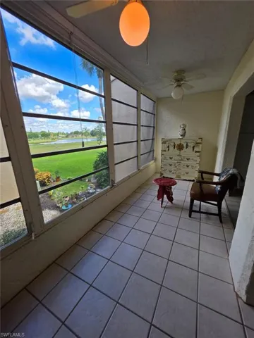 Sunroom / solarium with a water view and tile patterned floors