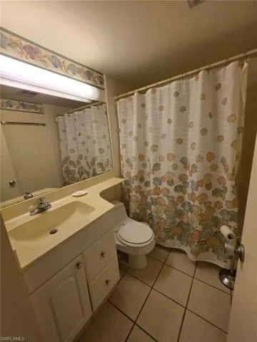 Full bath with light tile patterned flooring and vanity