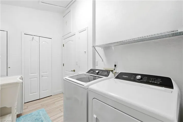 Laundry room with light tile  flooring. Washer/Dryer and Laundry Tub inside the house.