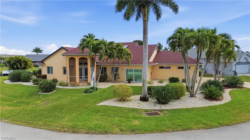 Front view of house featuring stucco siding and mature landscaping.