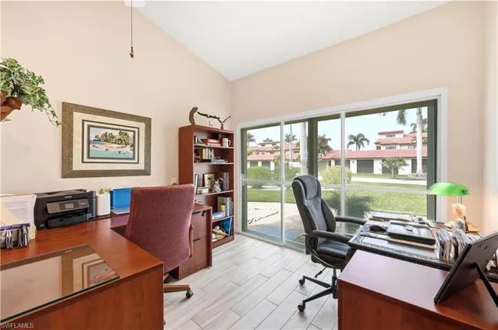Office featuring separate Sliding Glass Door Entrance and vaulted ceiling and Tile Floor.
