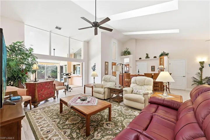 Living room with skylights, tile floors, vaulted ceiling, ceiling fan, and a 12' Pocket Sliding Glass door with Clerestory Windows above to achieve natural light