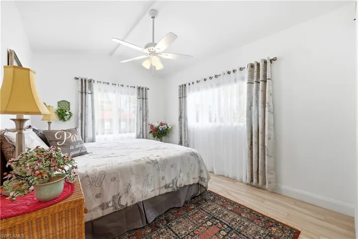Another Guest Bedroom with tile floors, vaulted ceiling, multiple windows, and a ceiling fan