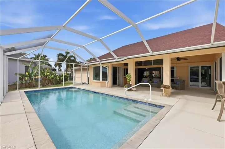 Saltwater Swimming pool with screen enclosure, a lanai area, and a patch of banana trees.
