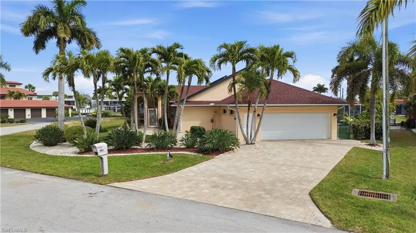 Single story home with Paver driveway, a front lawn, garage, and stucco siding