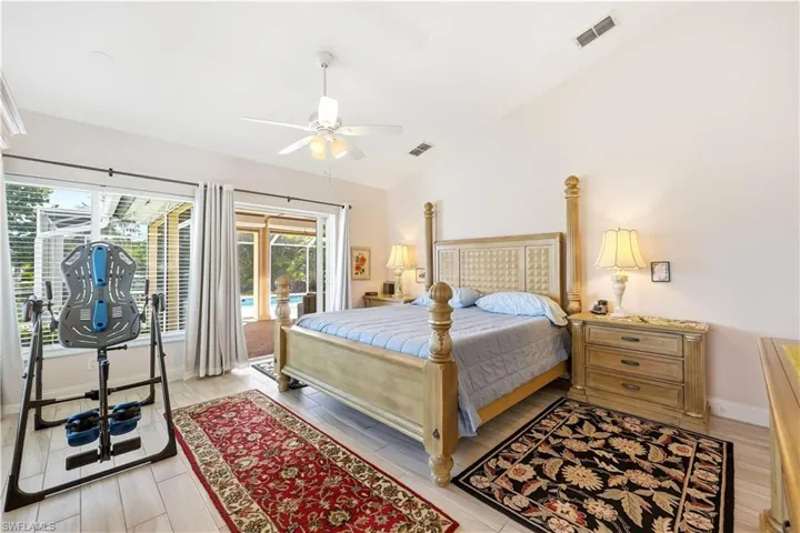 Master Bedroom Suite with Pocket Sliding Glass Door to the pool area, lofted ceiling, a ceiling fan, and tile floors.