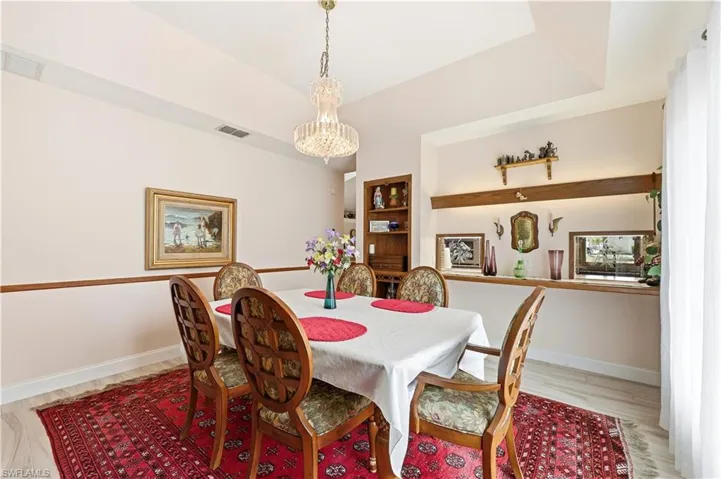 Dining room with light wood-style tile flooring and a chandelier