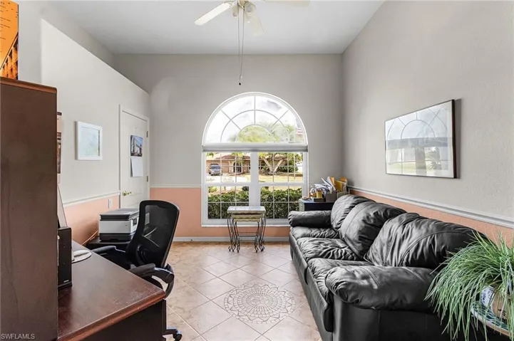 Third bedroom used as a Home office featuring light tile patterned flooring and ceiling fan