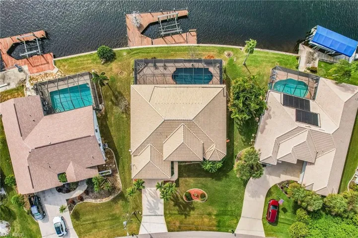 Drone / aerial view of a pool area, dock and lake.