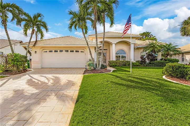 View of front of property with a paver driveway, an attached garage, and a tile roof