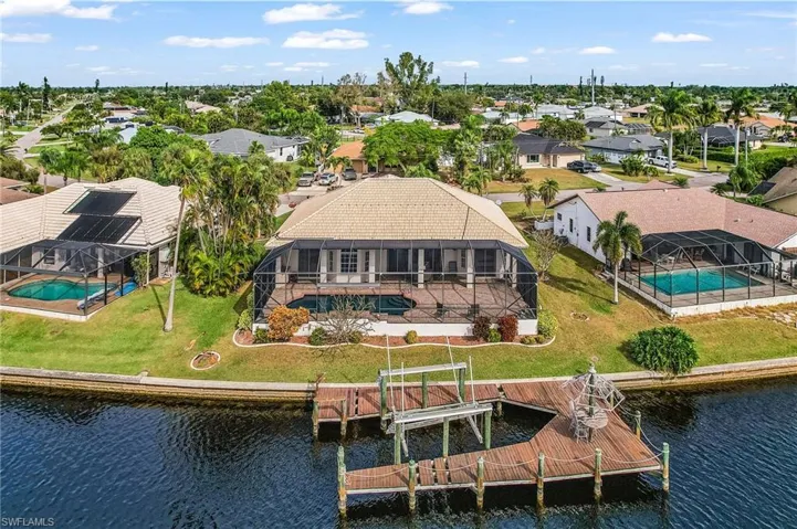 Aerial perspective of suburban area featuring a pool area and a large body of water