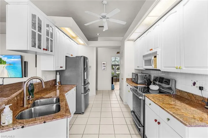 Kitchen featuring electric stove, glass insert cabinets, white cabinets, Granite counters