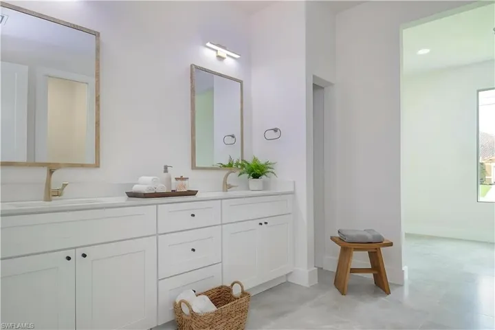 Bathroom featuring double vanity and baseboards