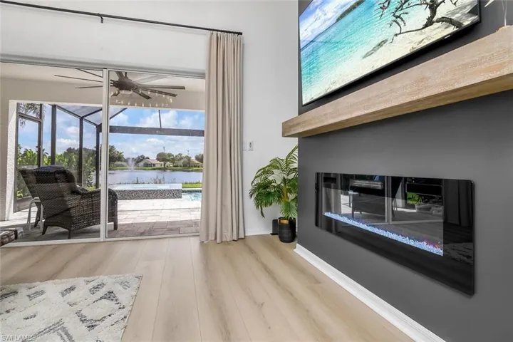 Doorway to outside featuring light hardwood / wood-style flooring, ceiling fan, and a water view