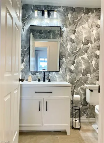 Bathroom with vanity, tasteful backsplash, toilet, and tile patterned flooring
