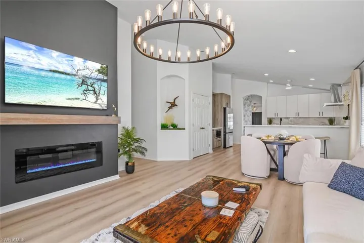 Living room with light hardwood / wood-style flooring and an inviting chandelier
