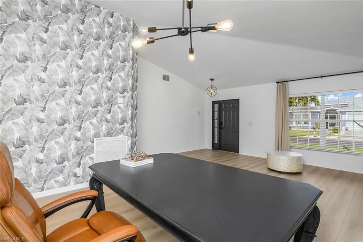 Home office featuring vaulted ceiling and light hardwood / wood-style floors