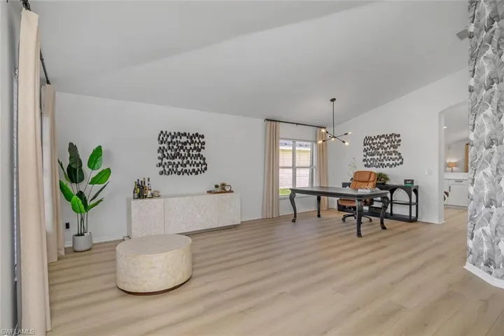 Dining space featuring lofted ceiling, a notable chandelier, and light hardwood / wood-style flooring