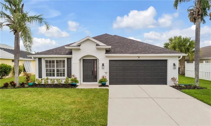 Ranch-style house featuring a garage and a front lawn