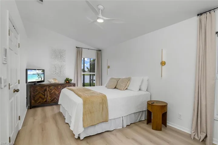 Bedroom featuring vaulted ceiling, light hardwood / wood-style flooring, and ceiling fan