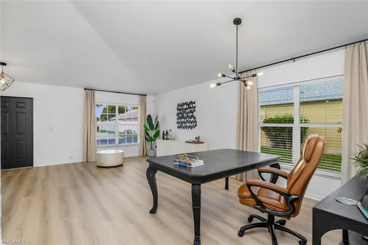 Home office featuring a notable chandelier and light hardwood / wood-style floors