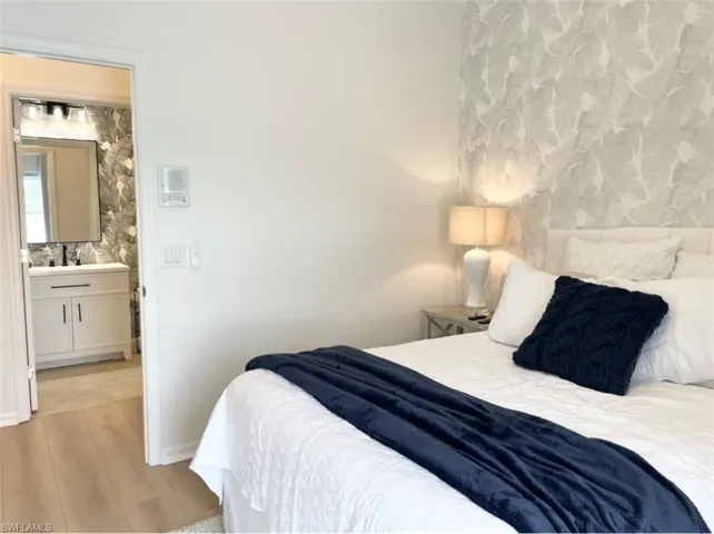 Bedroom with light wood-type flooring and ensuite bath