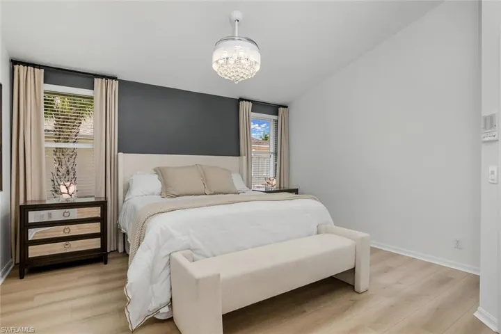 Bedroom featuring multiple windows, light hardwood / wood-style flooring, and a chandelier