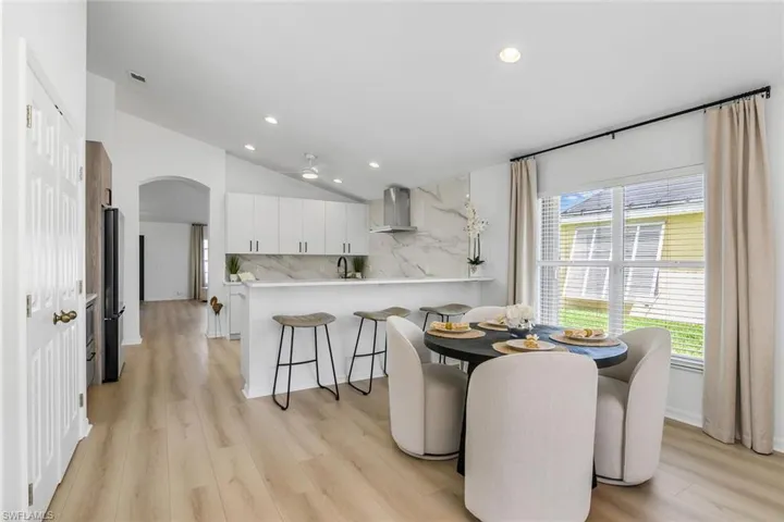Dining room featuring lofted ceiling, sink, and light wood-type flooring