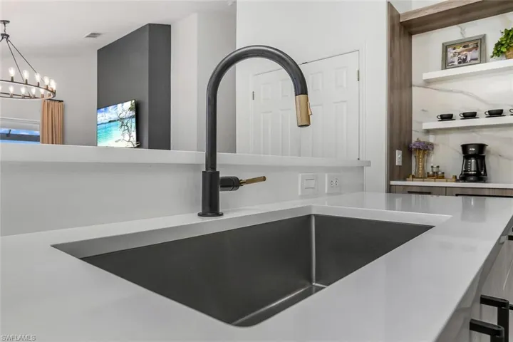 Interior details featuring pendant lighting, sink, and a chandelier