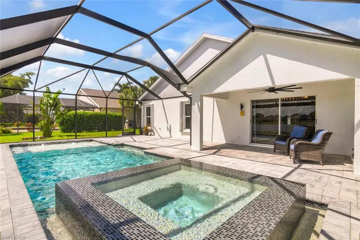 View of swimming pool with glass enclosure, an in ground hot tub, ceiling fan, and a patio