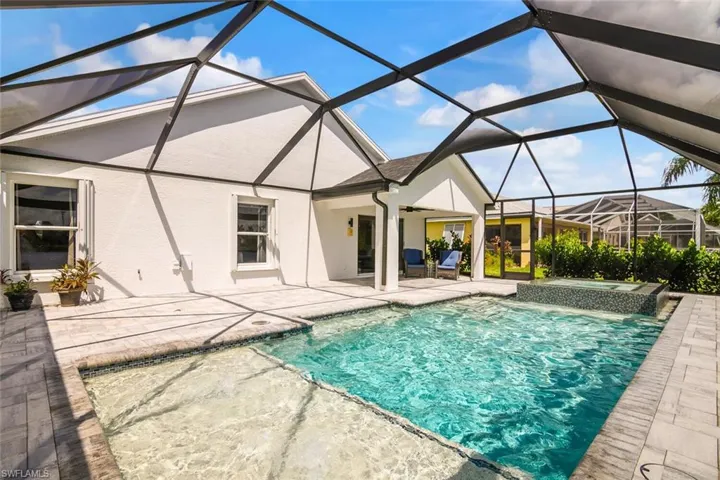 View of pool with glass enclosure and a patio area