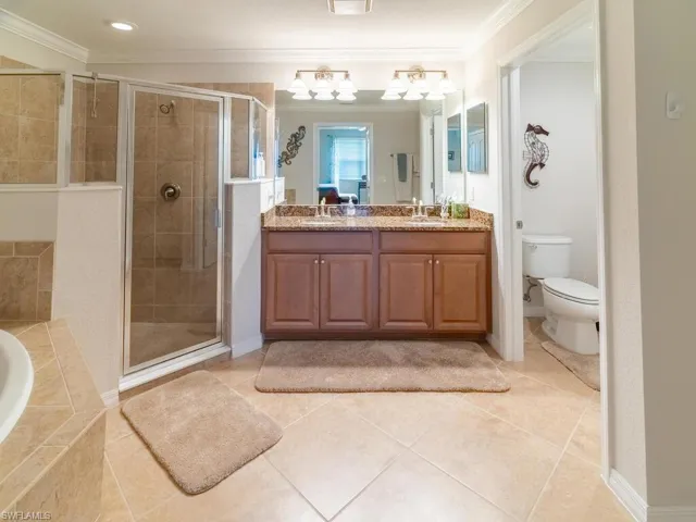 Full bathroom with vanity, toilet, independent shower and bath, and ornamental molding